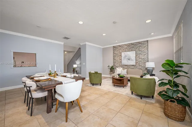 a dining room with furniture and a potted plant