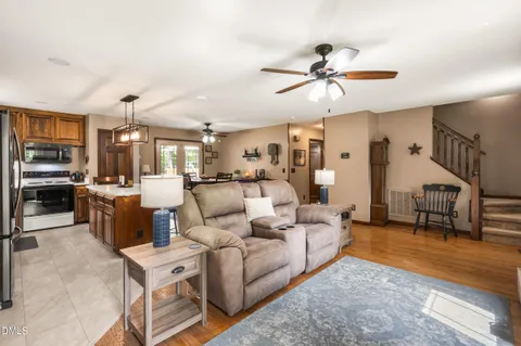 a living room with furniture kitchen view and a chandelier