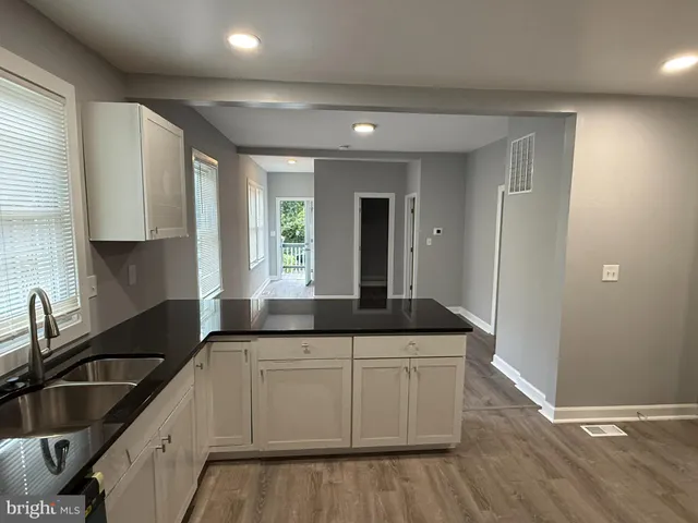 a kitchen with granite countertop a sink and cabinets