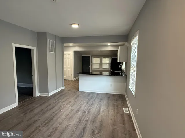 a view of a hallway with wooden floor and a chair