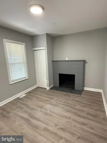 an empty room with windows and fireplace