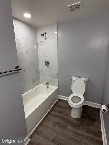 a bathroom with a sink toilet a mirror and bathtub