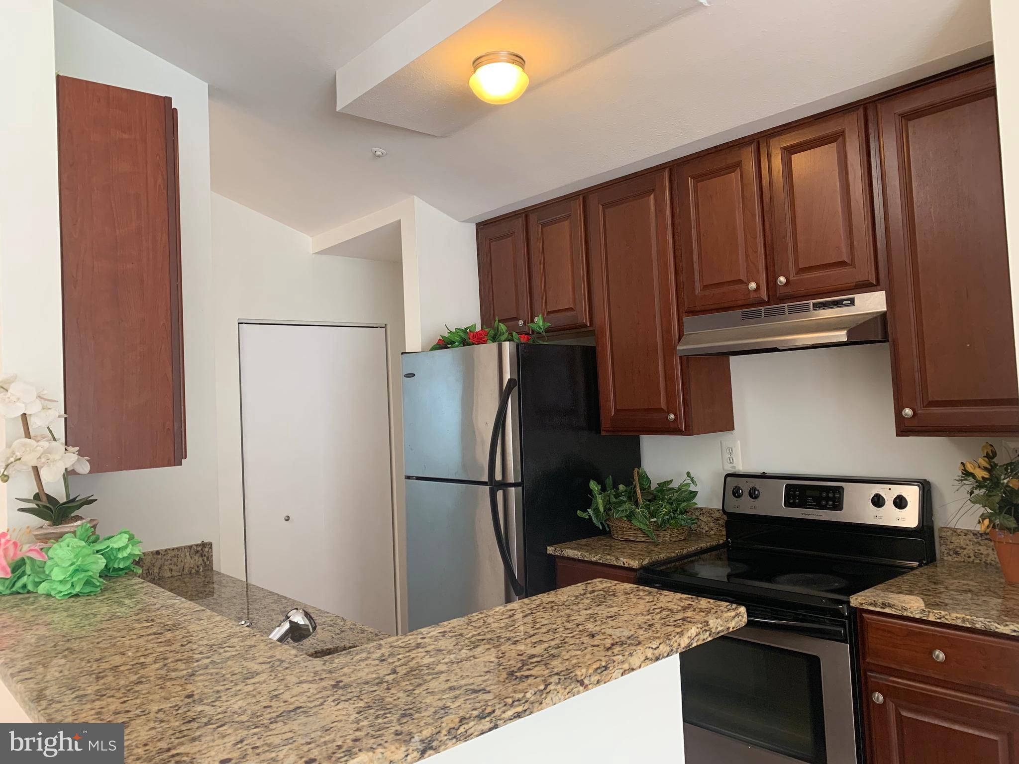a kitchen with granite countertop wooden cabinets and a stainless steel appliances