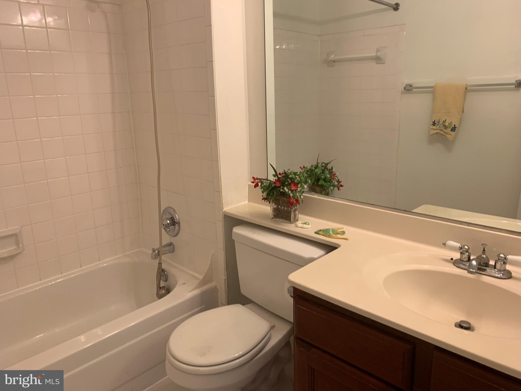 18533 Boysenberry Drive, Unit 288212 Gaithersburg, MD 20879 - Photo 13 of 17 a bathroom with a sink toilet and shower