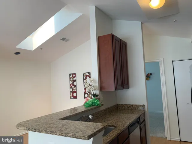 a kitchen with a granite countertop sink and refrigerator