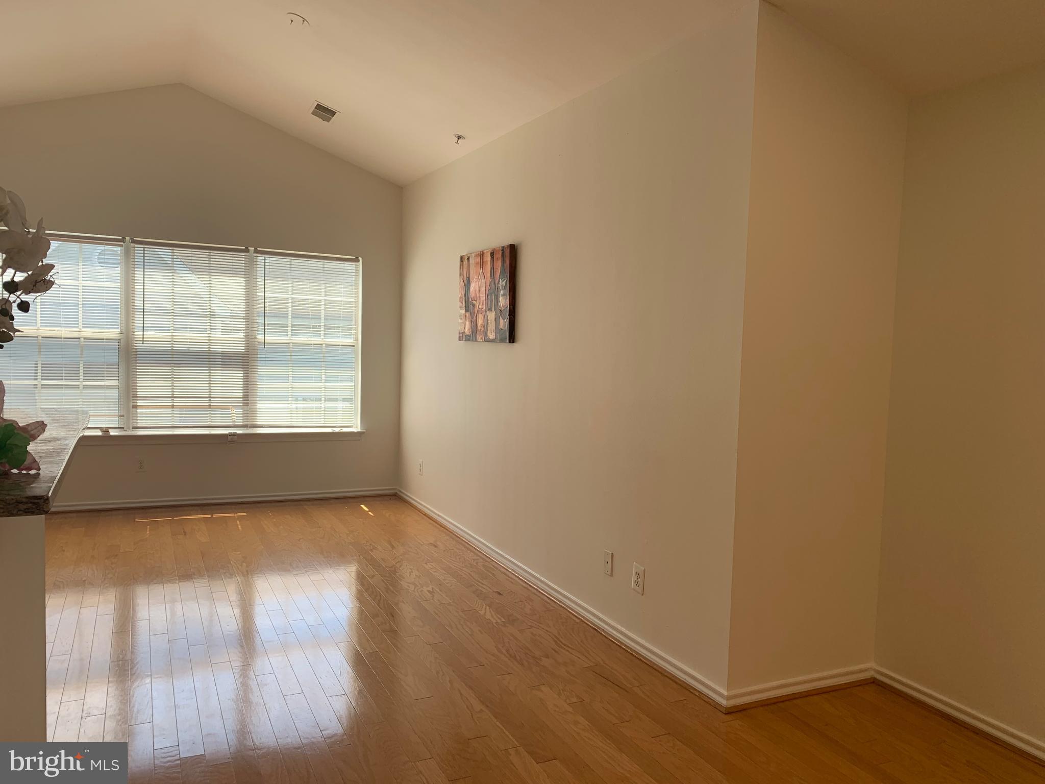 18533 Boysenberry Drive, Unit 288212 Gaithersburg, MD 20879 - Photo 3 of 17 an empty room with wooden floor and windows