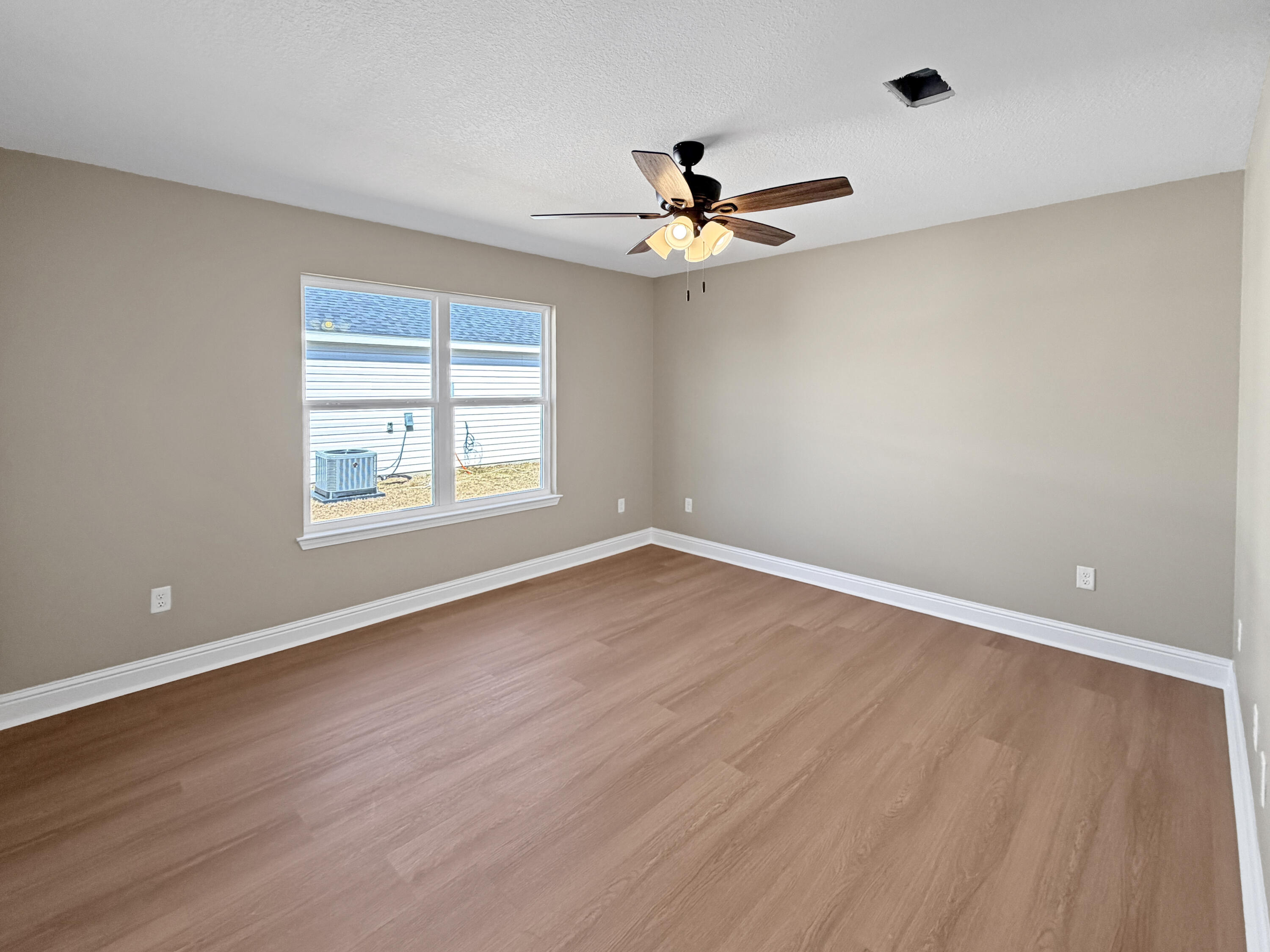 5356 Highview Drive Crestview, FL 32539 - Photo 13 of 18 an empty room with wooden floor fan and windows