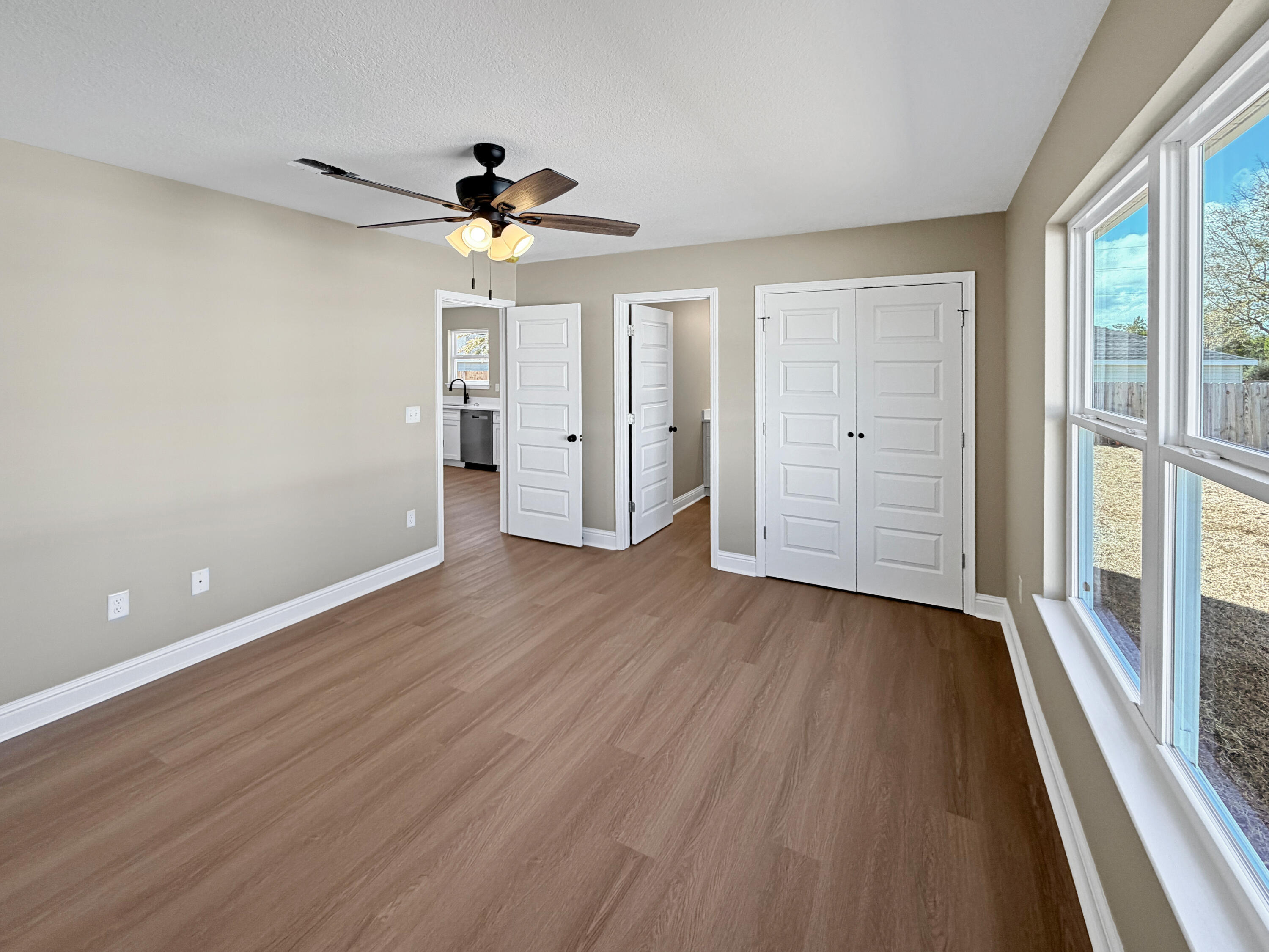 5356 Highview Drive Crestview, FL 32539 - Photo 14 of 18 a view of a room with wooden floor a ceiling fan and windows