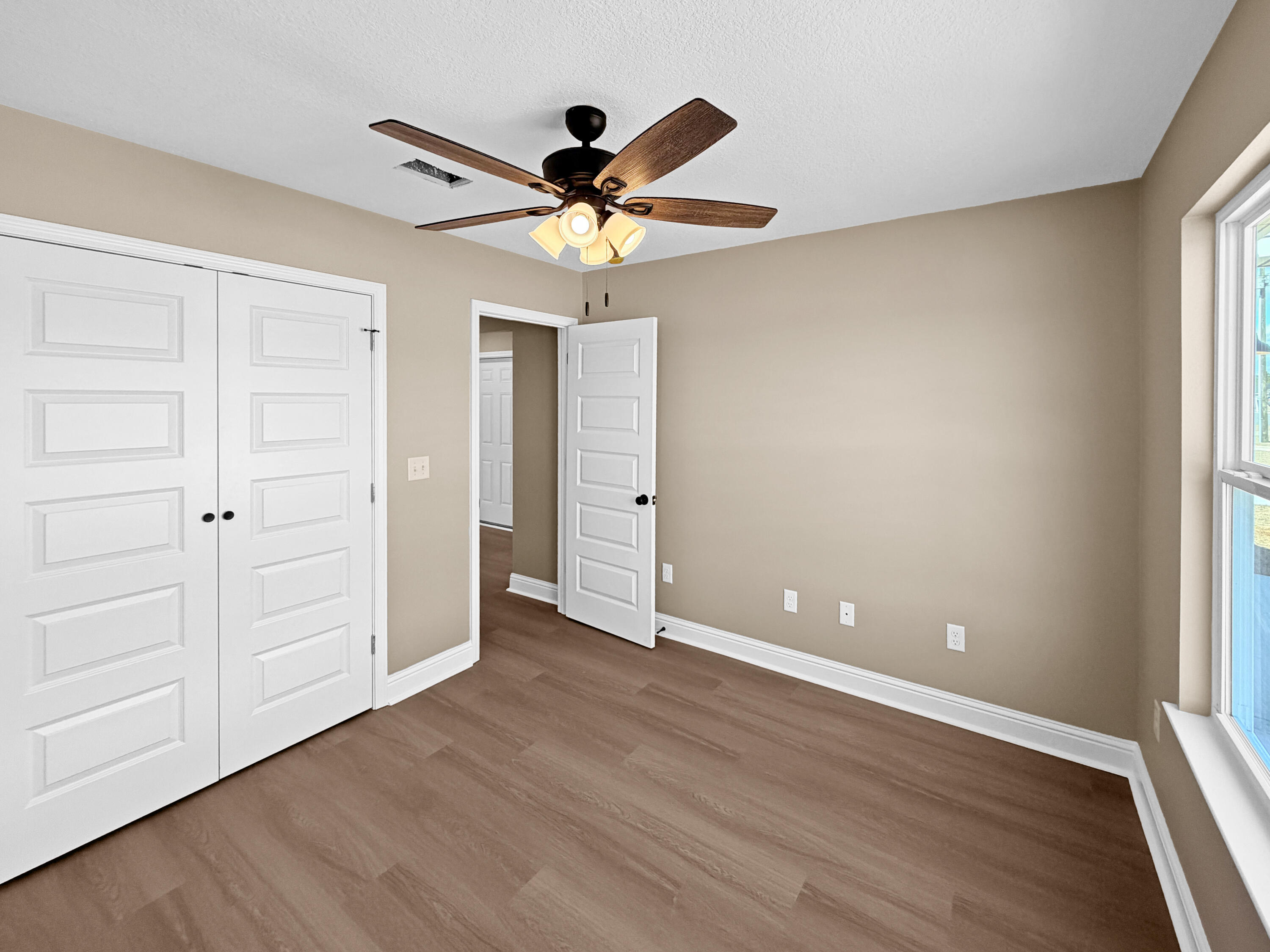 5356 Highview Drive Crestview, FL 32539 - Photo 9 of 18 wooden floor in an empty room with a window
