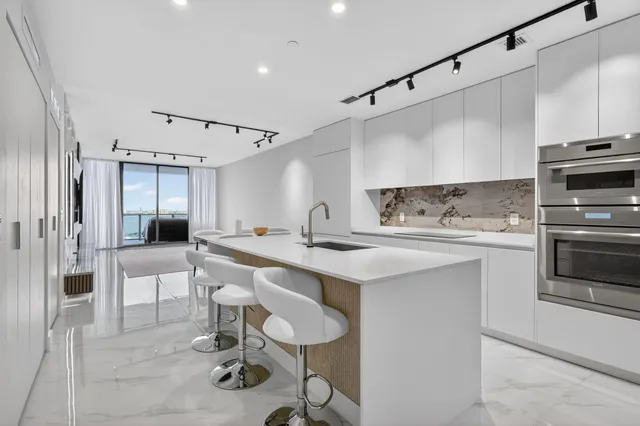 a kitchen with white cabinets and stainless steel appliances