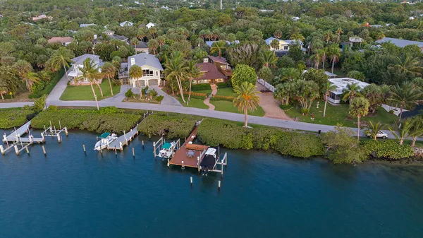 an aerial view of a house with a garden and lake view