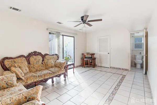 a living room with furniture and a ceiling fan