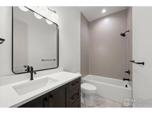 a bathroom with a sink a toilet a mirror and bathtub