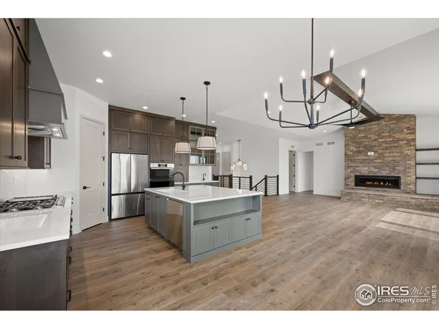 a large kitchen with cabinets wooden floor and stainless steel appliances