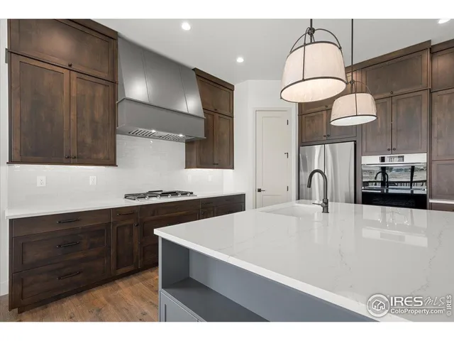 a kitchen with stainless steel appliances a sink cabinets and wooden floor