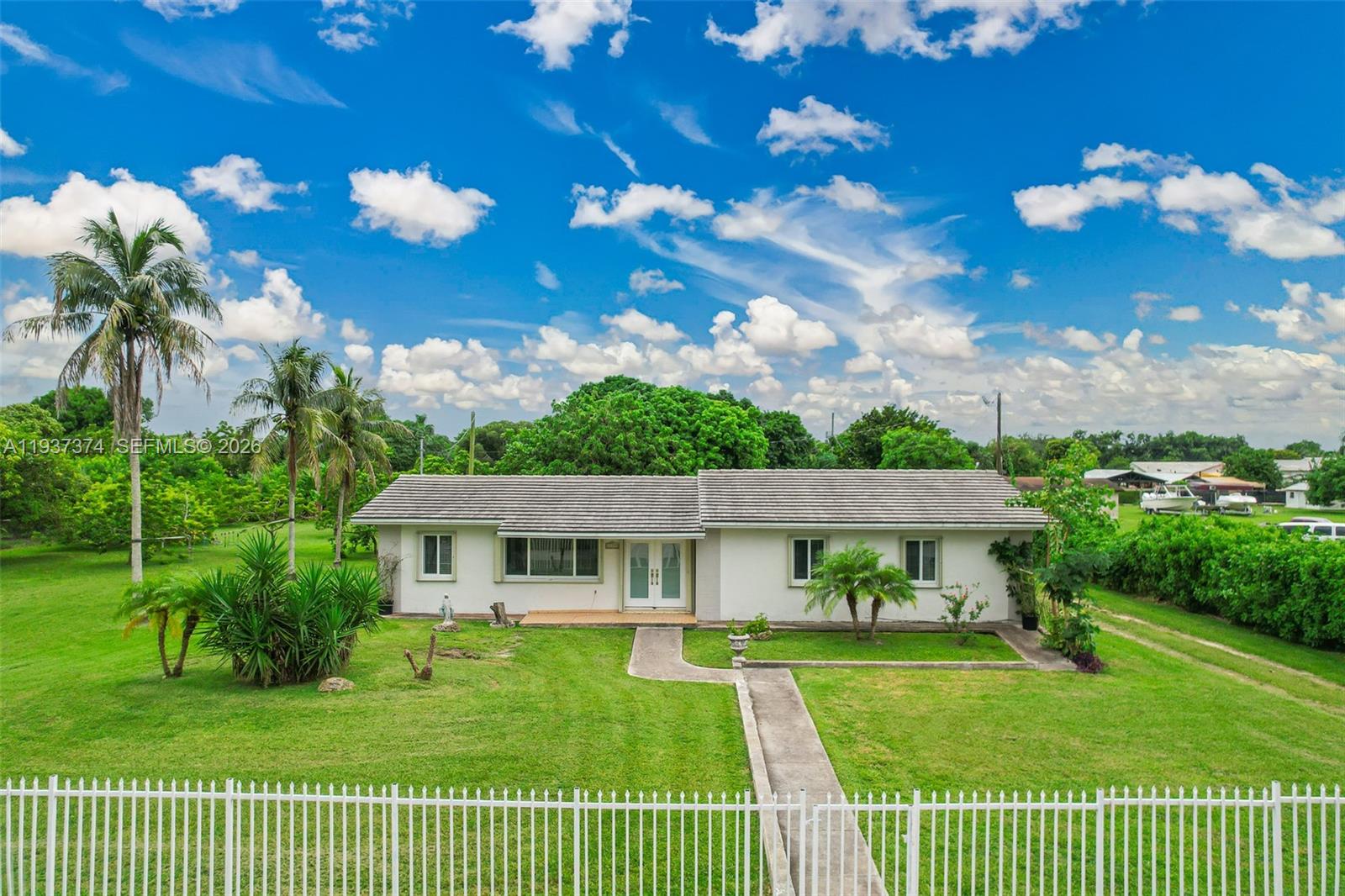 20890 Southwest 236th Street Homestead, FL 33031 - Photo 2 of 47 a view of a house with a big yard potted plants and large tree