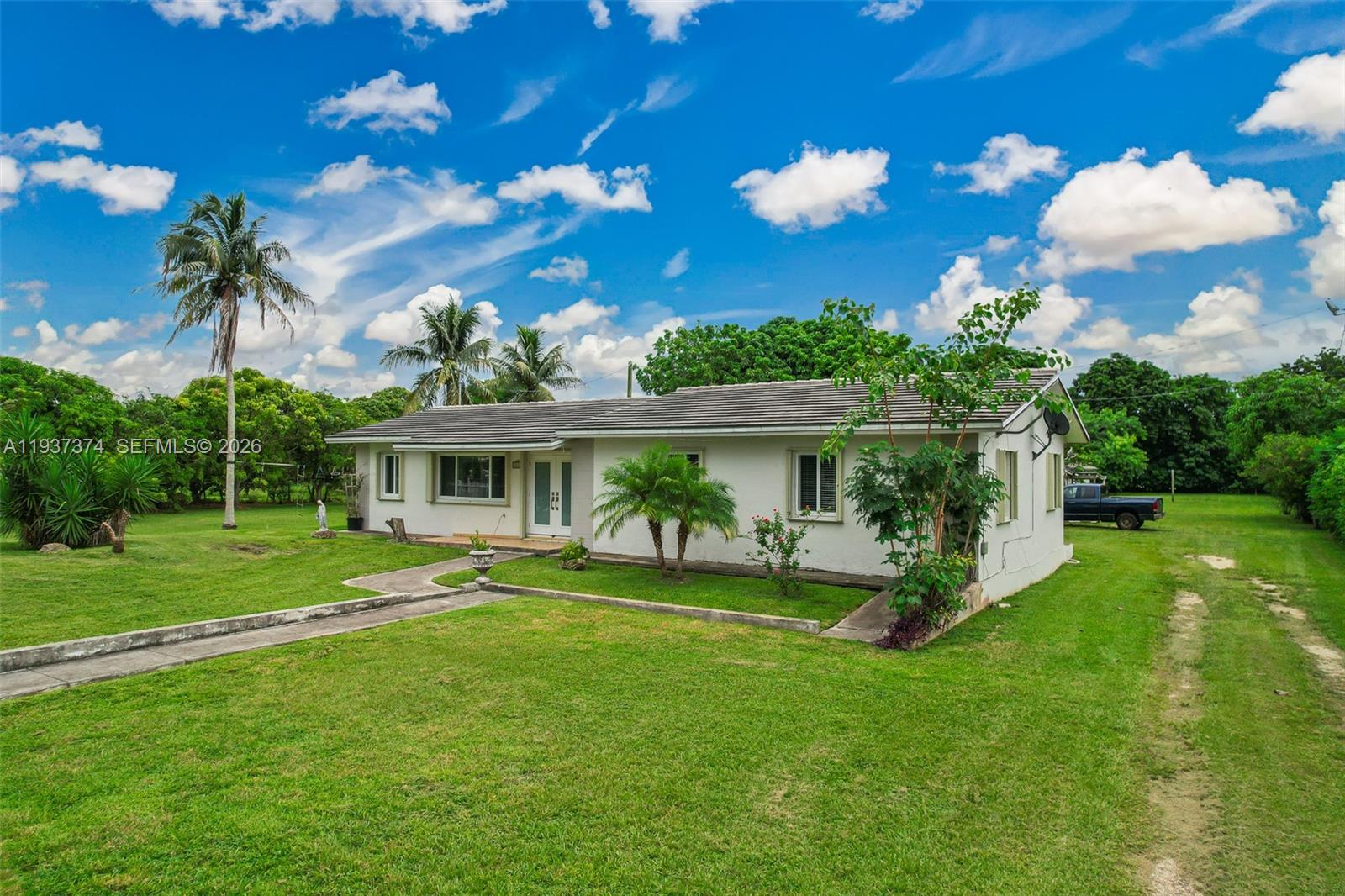 20890 Southwest 236th Street Homestead, FL 33031 - Photo 3 of 47 a view of a house with a big yard and potted plants