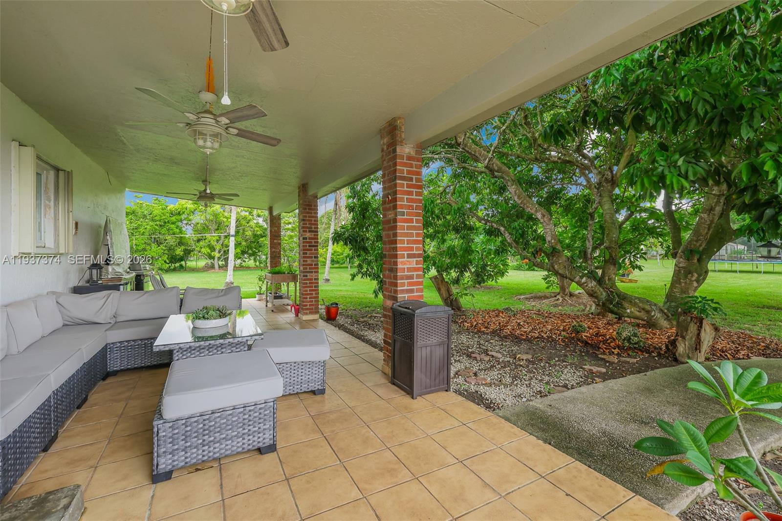20890 Southwest 236th Street Homestead, FL 33031 - Photo 37 of 47 a living room with patio furniture and a garden