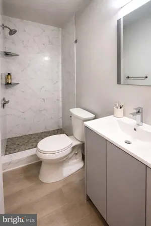 a bathroom with a sink a toilet and shower
