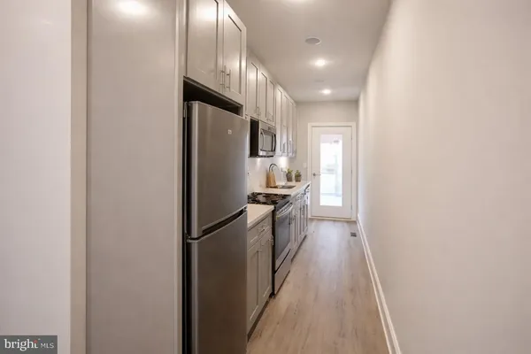 a kitchen with kitchen island a counter top space and stainless steel appliances