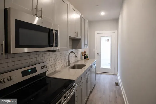 a kitchen with stainless steel appliances a sink stove and microwave