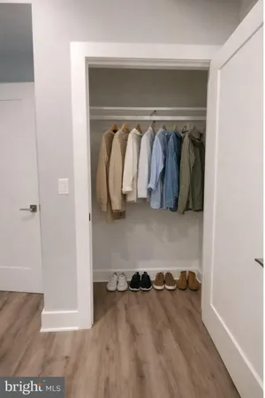 a view of walk in closet with clothes and shoes