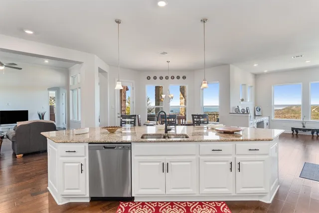 a kitchen with granite countertop a sink cabinets and wooden floor