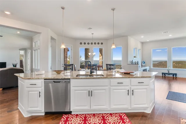 a kitchen with granite countertop a sink cabinets and wooden floor
