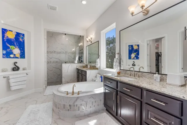 a bathroom with a granite countertop sink mirror bathtub and toilet