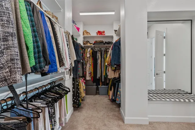 a view of walk in closet with clothes and shoes