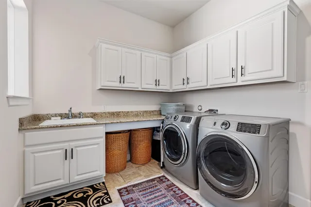 a utility room with sink dryer and washer