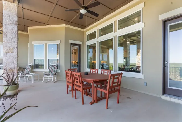 a dining room with furniture and large windows