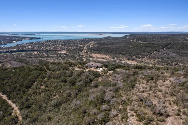 an aerial view of house with yard and mountain view in back