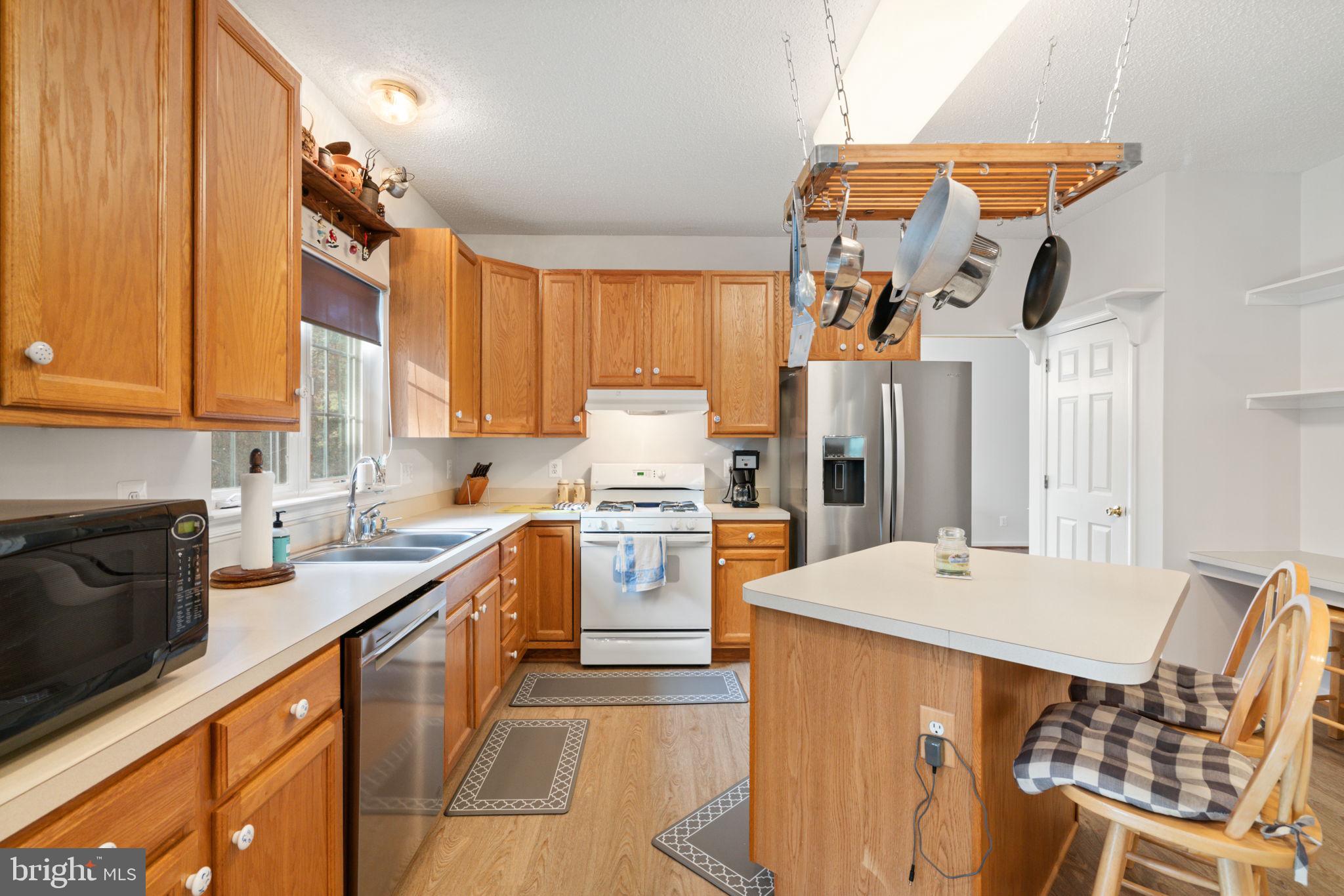 14760 Peach Tree Lane King George, VA 22485 - Photo 11 of 40 a kitchen with a table chairs sink stove and refrigerator