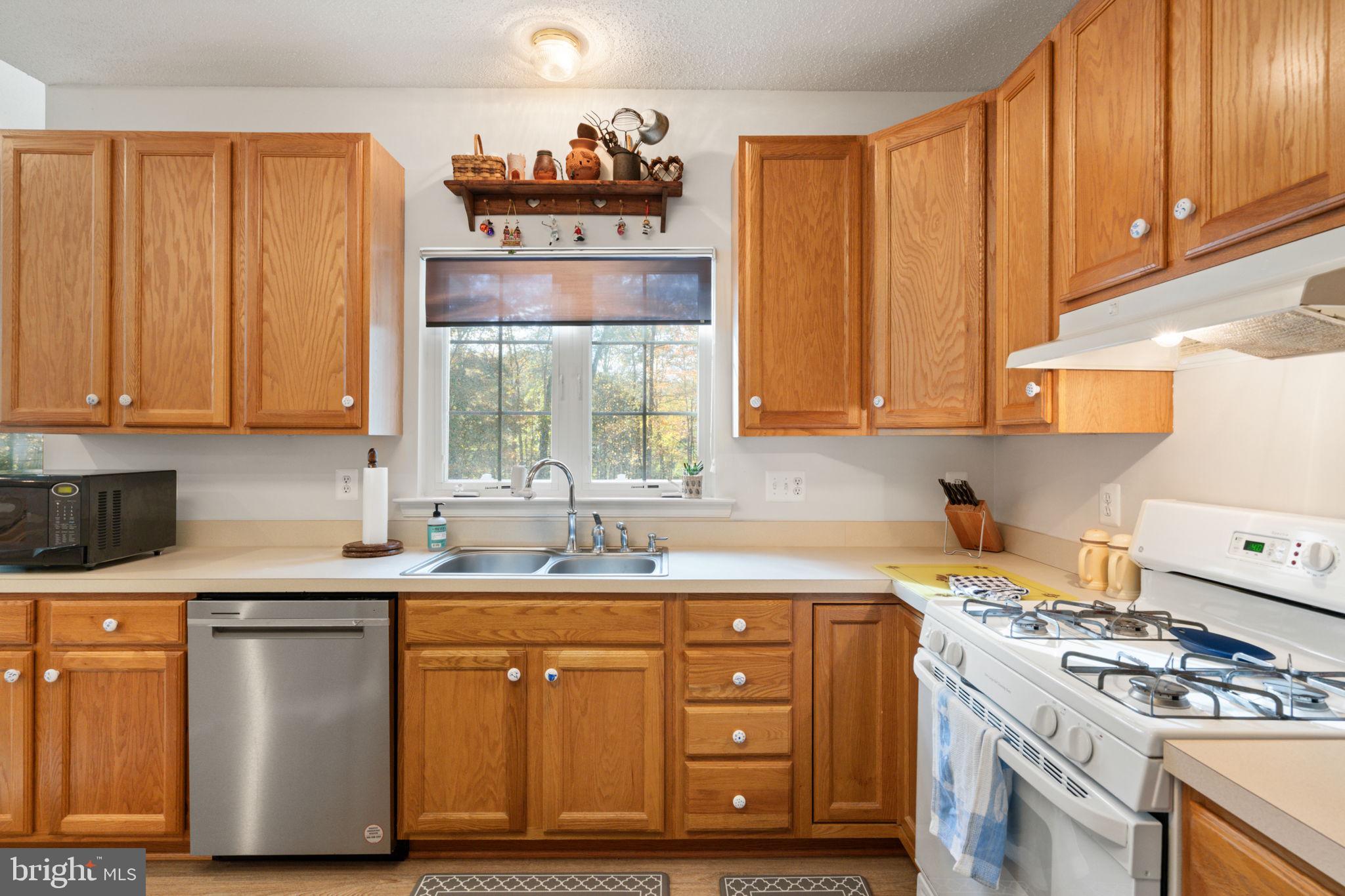 14760 Peach Tree Lane King George, VA 22485 - Photo 10 of 40 a kitchen with stainless steel appliances granite countertop a sink a stove and a wooden cabinets