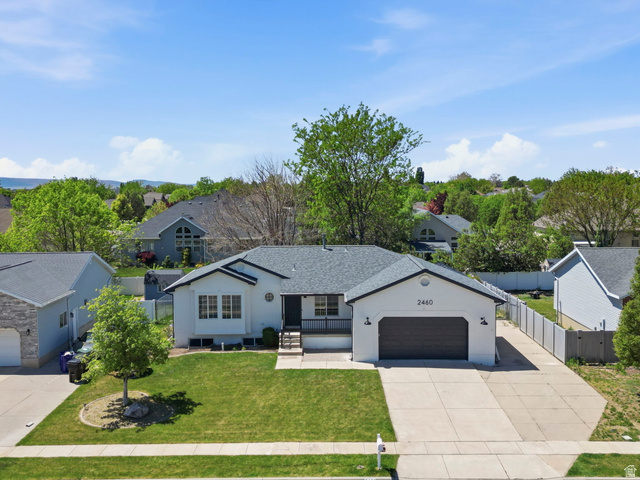 2460 Allison Way Syracuse, UT 84075 - Photo 2 of 24 Single-story residence featuring a dark gray asphalt shingle roof and a two-car garage with a dark wood-finish door