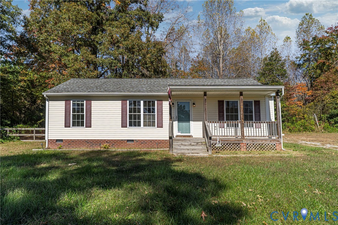 a white house with a large garden in front of it