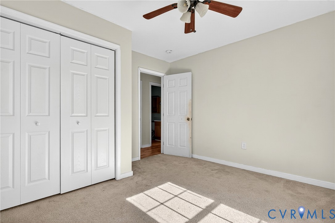 1611 Howerton Road Dunnsville, VA 22454 - Photo 11 of 36 an empty room with chandelier fan