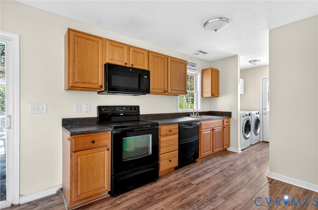1611 Howerton Road Dunnsville, VA 22454 - Photo 15 of 36 a kitchen with stainless steel appliances granite countertop a stove top oven microwave and refrigerator