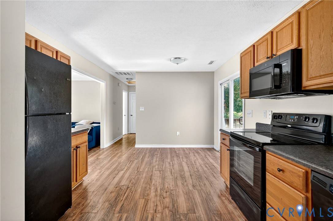 1611 Howerton Road Dunnsville, VA 22454 - Photo 16 of 36 a kitchen with stainless steel appliances granite countertop a stove a sink and a refrigerator