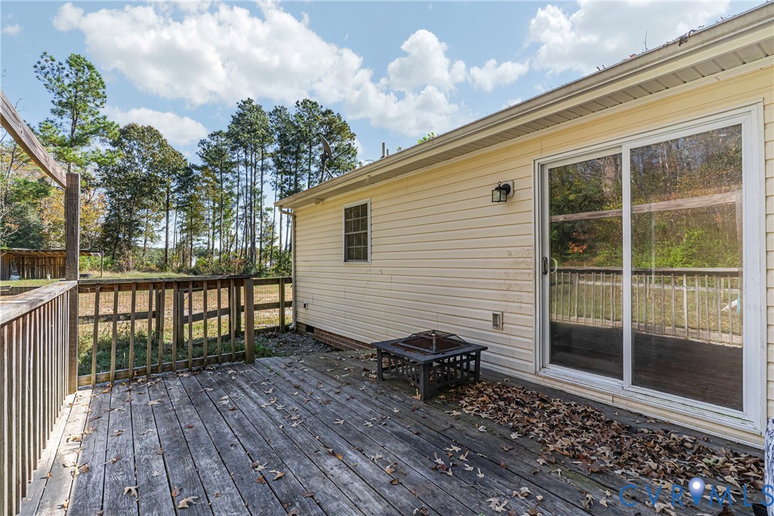 1611 Howerton Road Dunnsville, VA 22454 - Photo 20 of 36 a balcony with a table and chairs and wooden floor