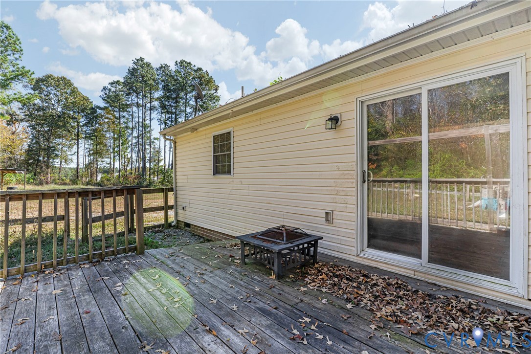 1611 Howerton Road Dunnsville, VA 22454 - Photo 22 of 36 a view of a wooden deck with a bench