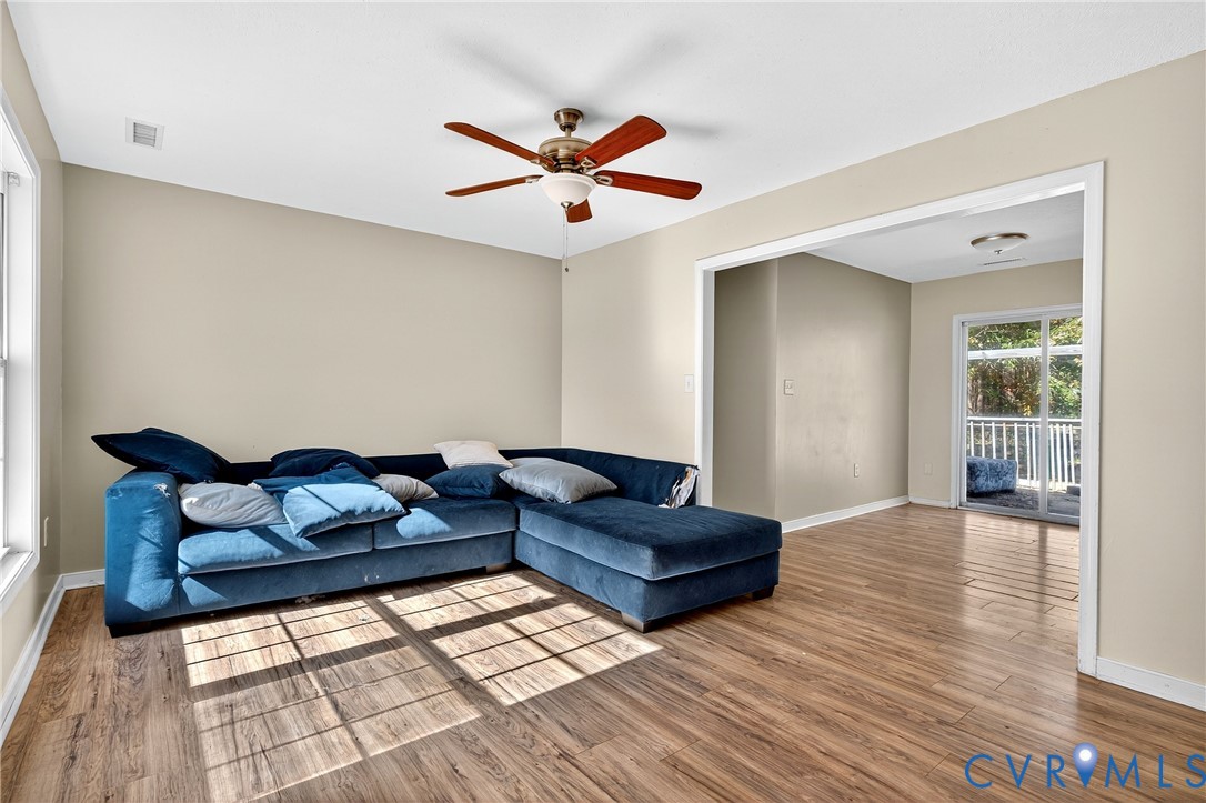 1611 Howerton Road Dunnsville, VA 22454 - Photo 4 of 36 a living room with couches and kitchen view with wooden floor