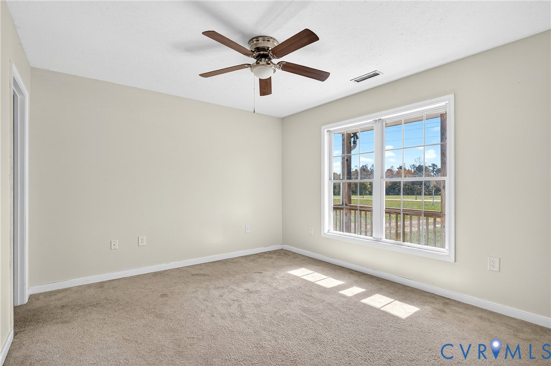 1611 Howerton Road Dunnsville, VA 22454 - Photo 6 of 36 an empty room with ceiling fan and windows