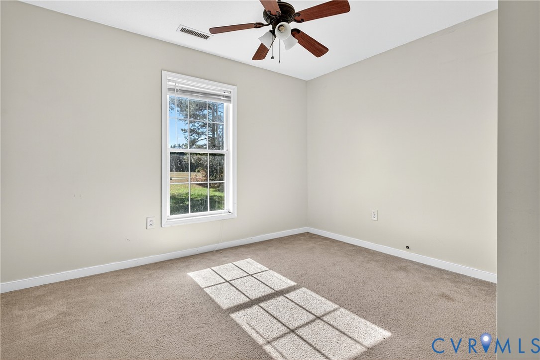 1611 Howerton Road Dunnsville, VA 22454 - Photo 10 of 36 an empty room with windows and fan