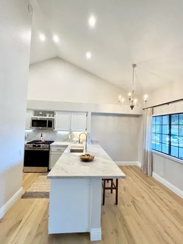 a kitchen with a sink cabinets and wooden floor