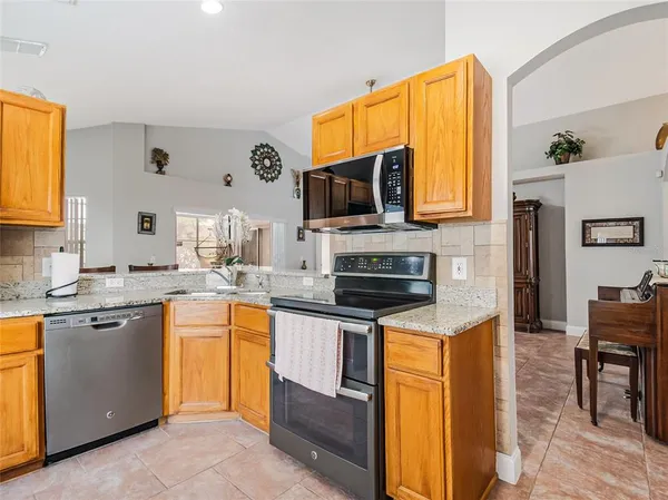 a kitchen with stainless steel appliances granite countertop a refrigerator and a stove top oven