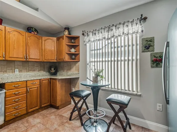 a utility room with stainless steel appliances cabinets and a window