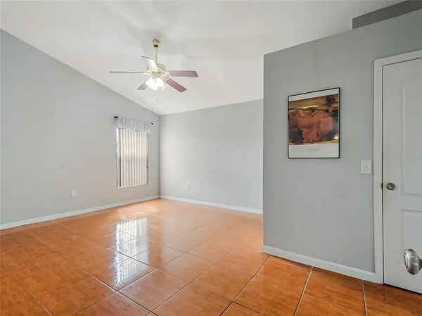 a view of an empty room with cabinet and a chandelier fan