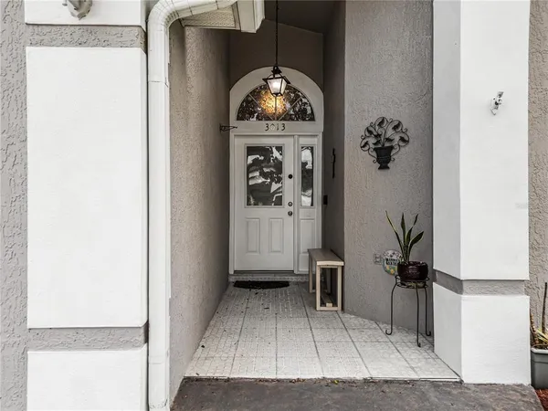 a view of a livingroom with wooden floor a chandelier and entryway